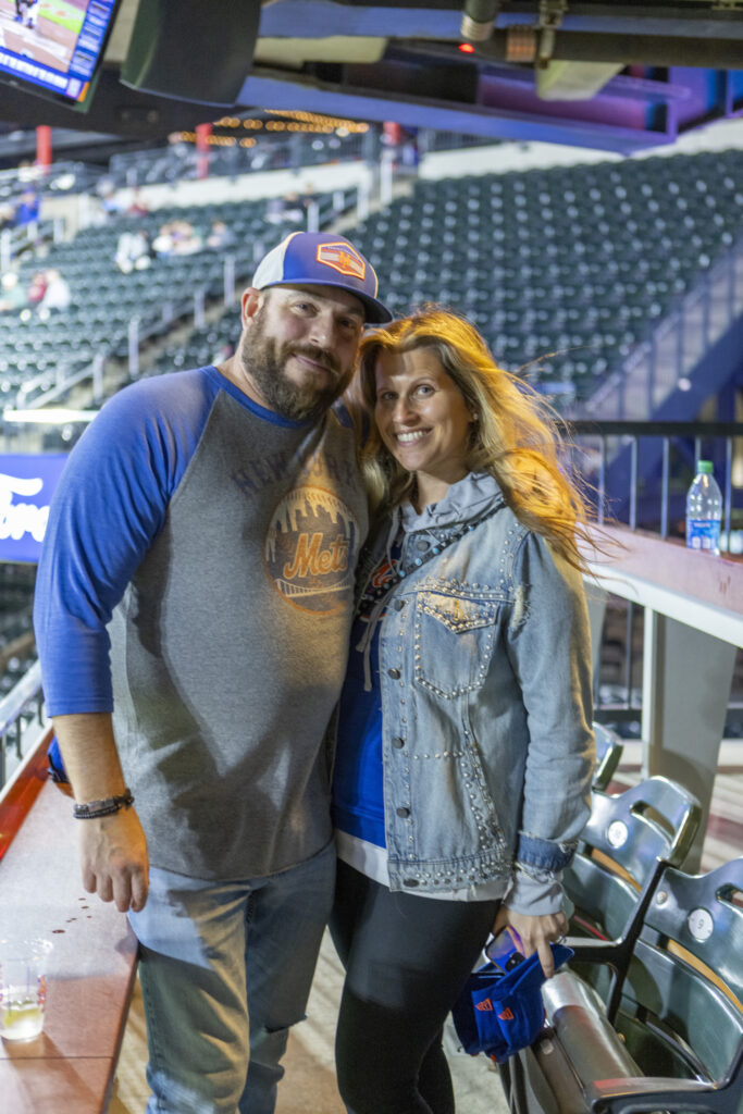 Two Chopra & Nocerino team members posing for picture at NY Mets game where they threw the opening pitch