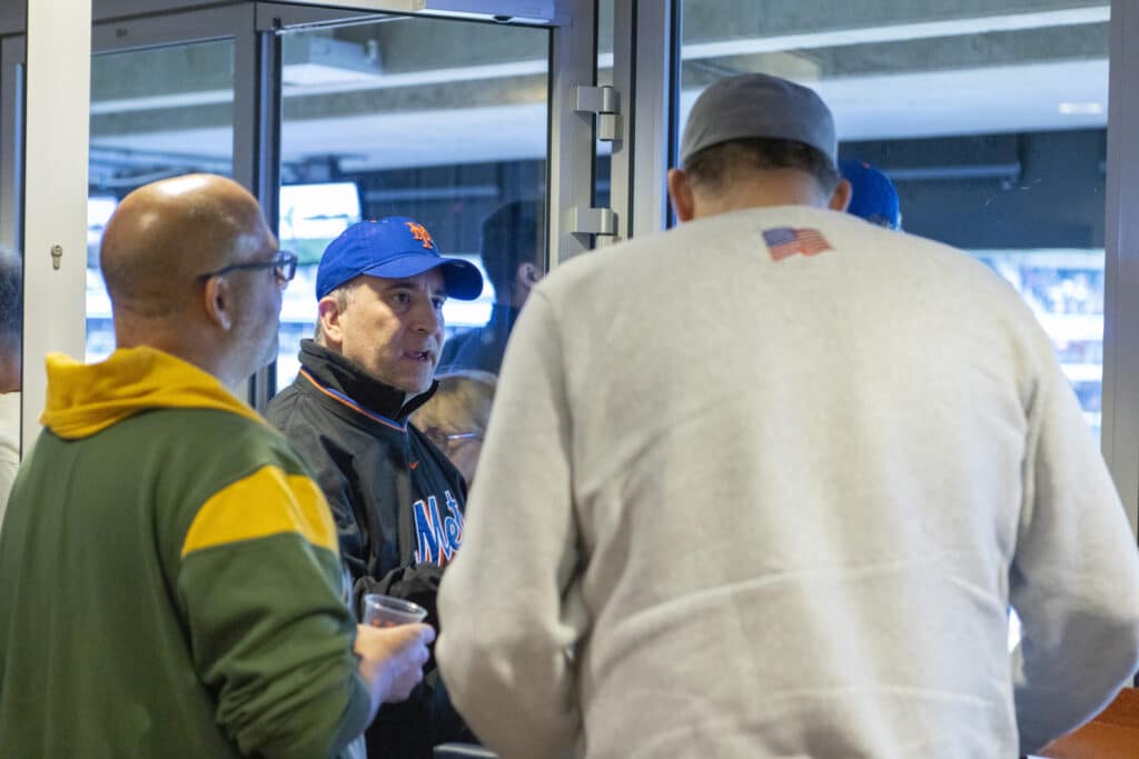 Several men of the Chopra & Nocerino team conversing at New York Mets game