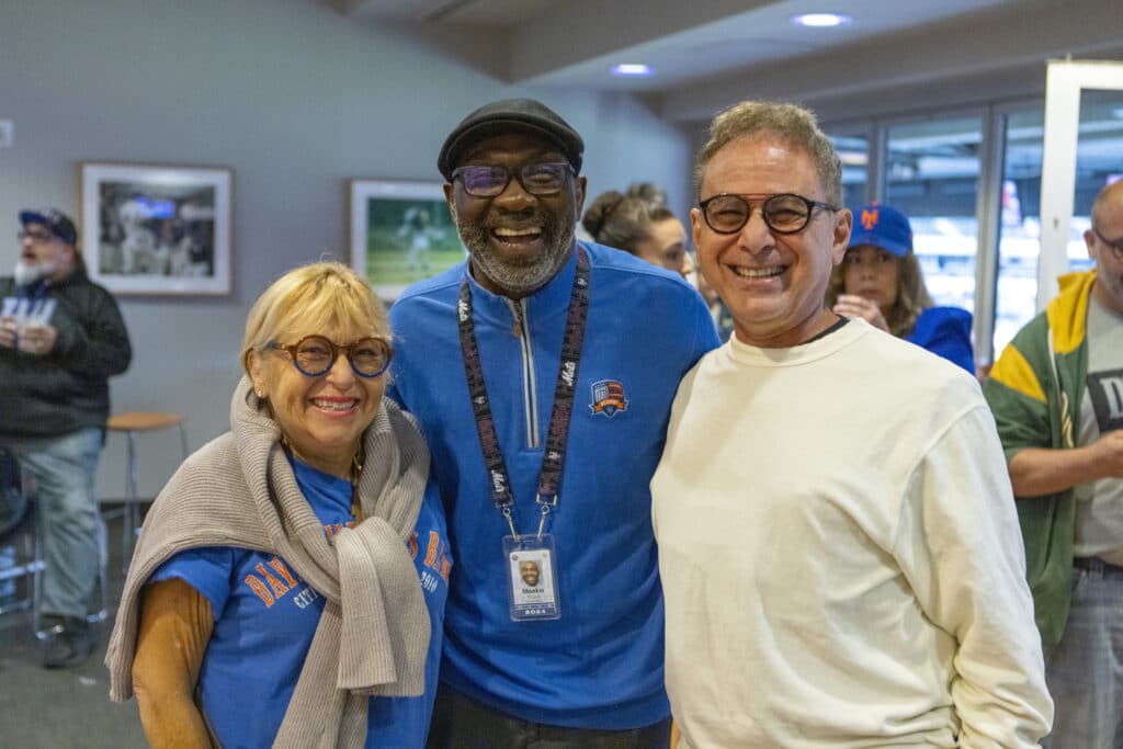 Team members of Chopra & Nocerino smiling at New York Mets game