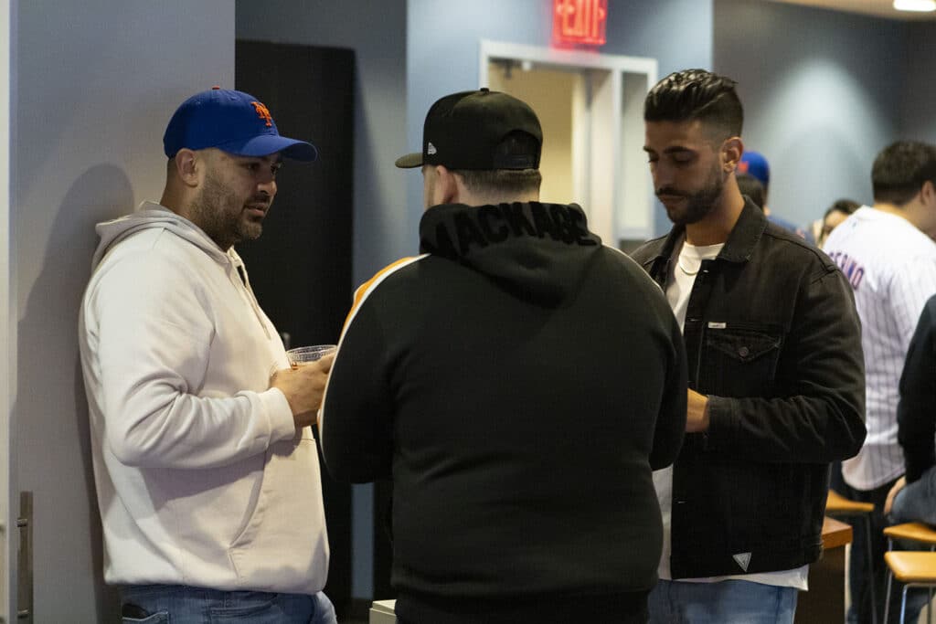 Team members of Chopra & Nocerino conversing at New York Mets game