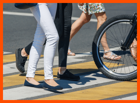 The image shows a close-up view of people crossing a pedestrian crosswalk.