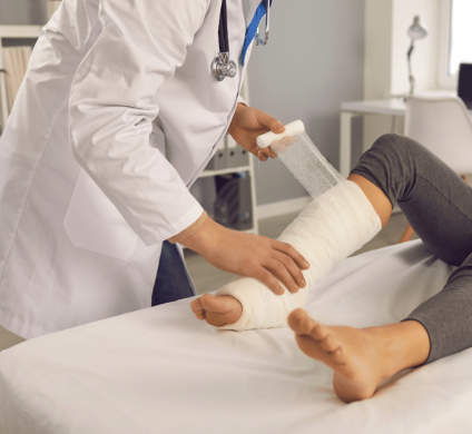 Woman getting her leg wrapped in a cast after an accident caused bodily injury to her