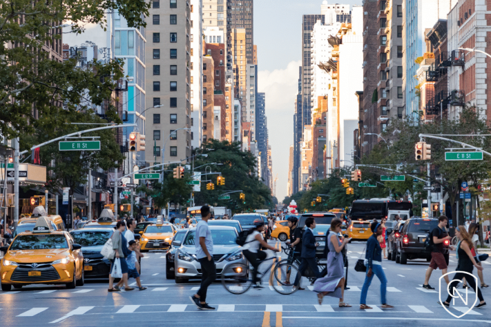 Street view of New York City traffic and pedestrians crossing the street