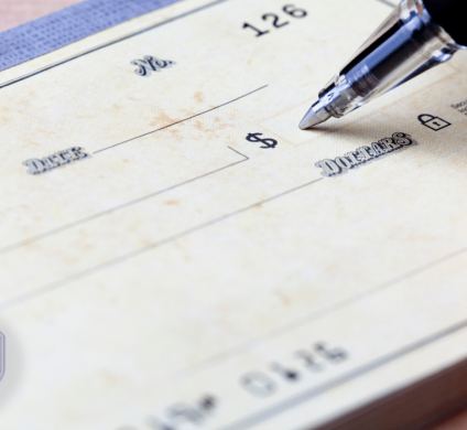 close up of someone writing in a check book
