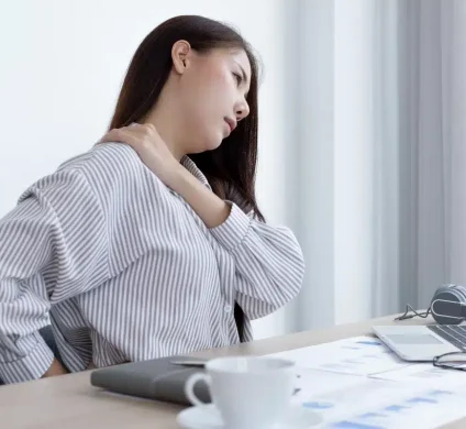 Woman in pain that is rubbing her shoulder/neck a few days after an accident